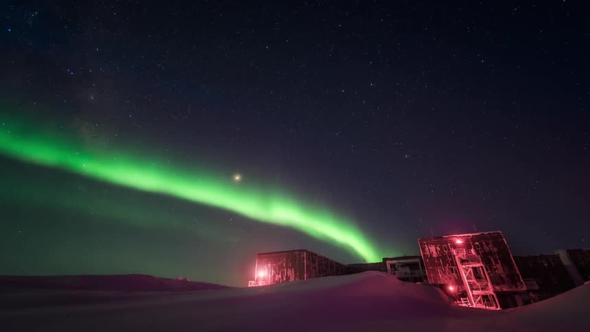 A person in the arctic at night observing the sky with Aurora Australis