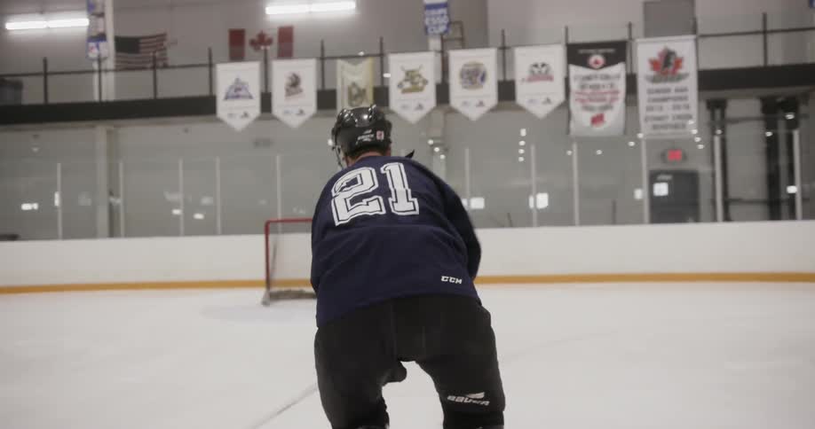 A man skating around a rink with a stick in his hand hitting a puck