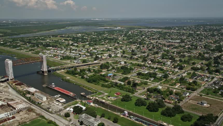 Ships move through a canal near a suburban area