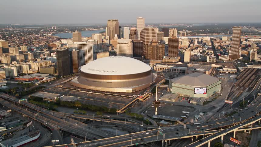 Aerial panorama of a stadium amidst a seaside metropolis