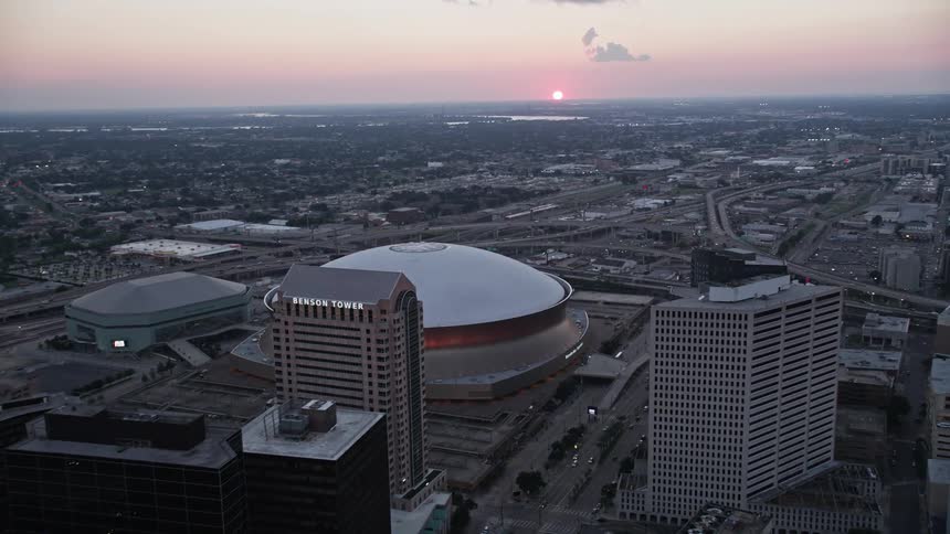 Aerial panorama of a stadium in the middle of a metropolis with the skyscraper and the sunset on the horizon