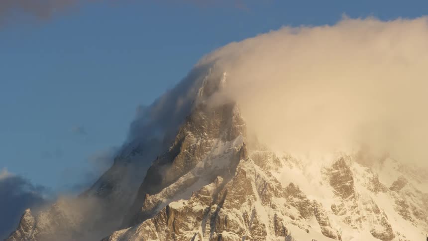 Panorama of a rocky mountain during a blizzard in winter at dawn