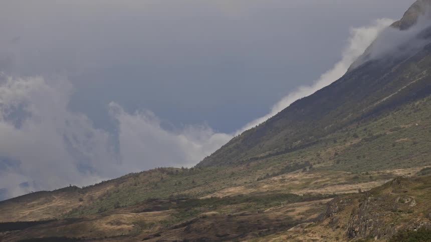 Birds fly by a large mountain