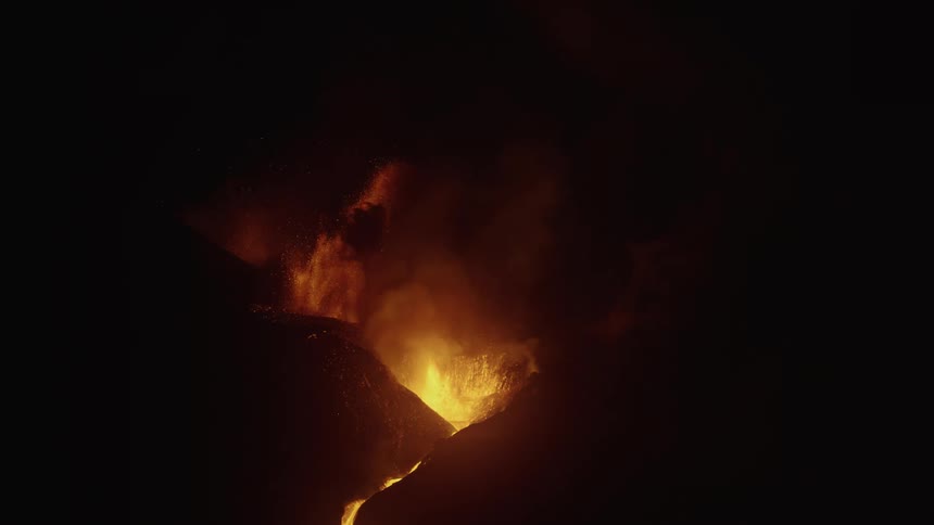 A volcanic eruption with a lot of lava splashing up through the mountains one night