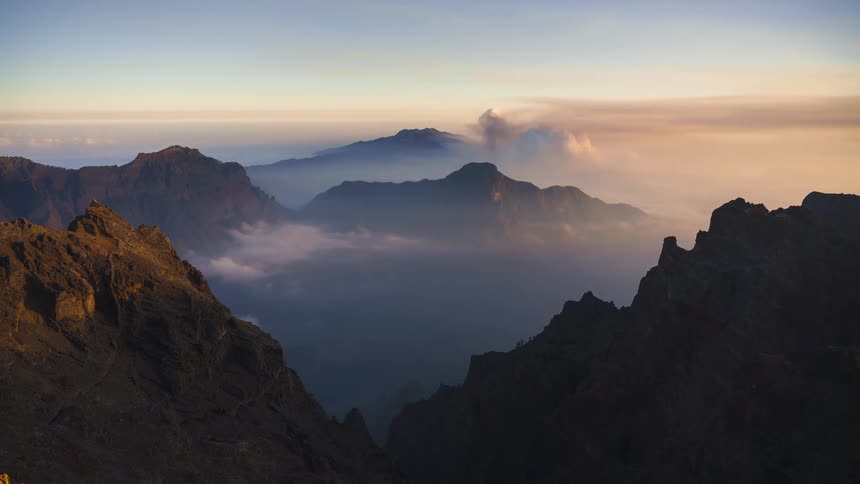 The clouds flow over the mountains