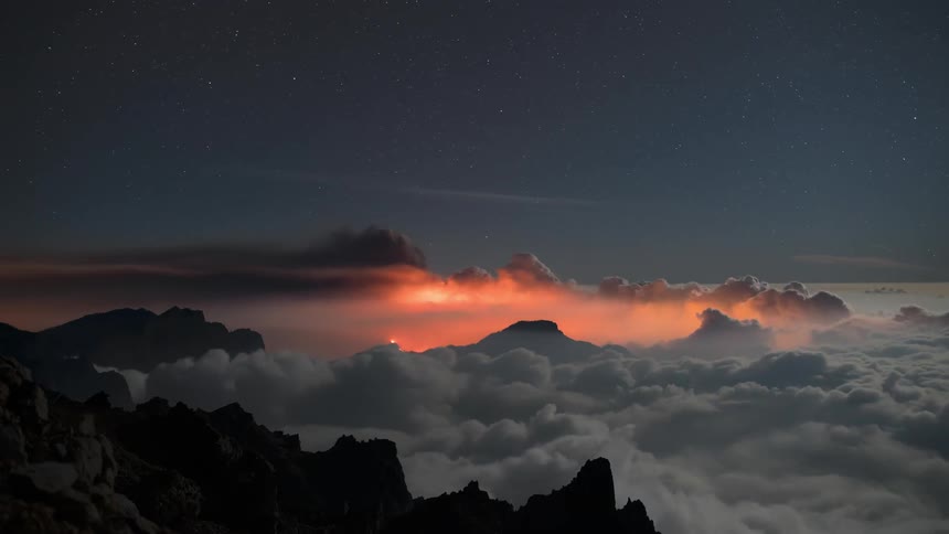 Aerial of a volcanic mountain covered by clouds during dusk
