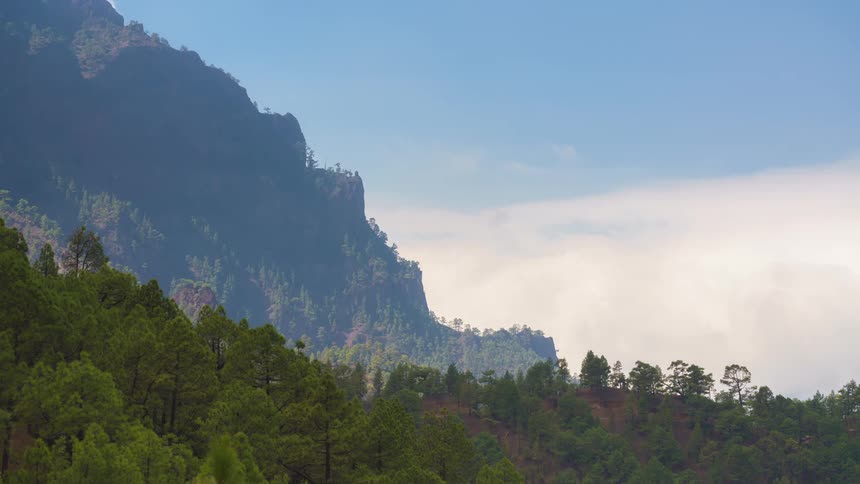 Clouds fill the sky over a mountain and forest