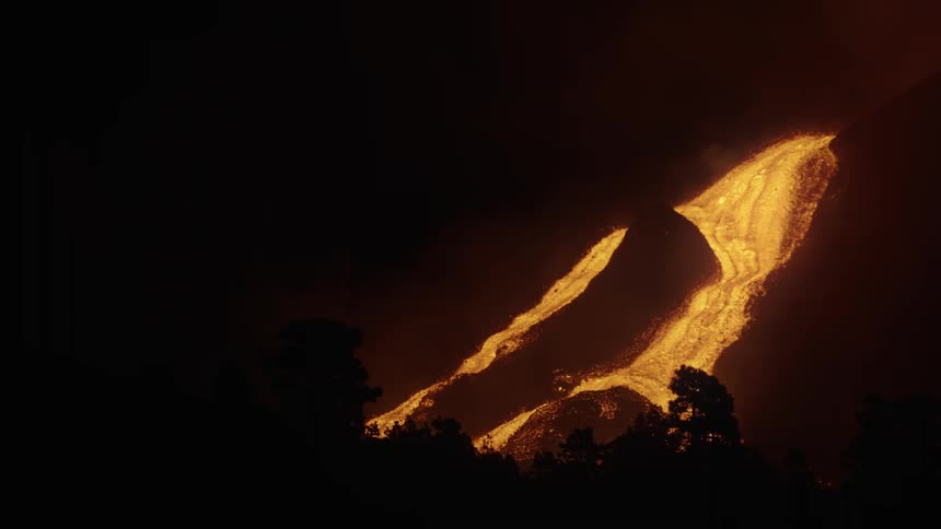 Lava slowly rolling down the side of a volcano