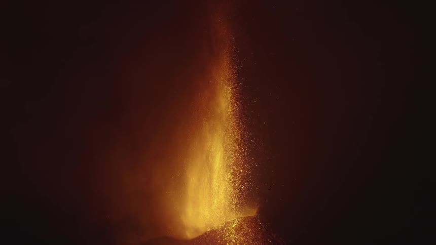 A volcanic eruption with bright lava and ash against a dark background