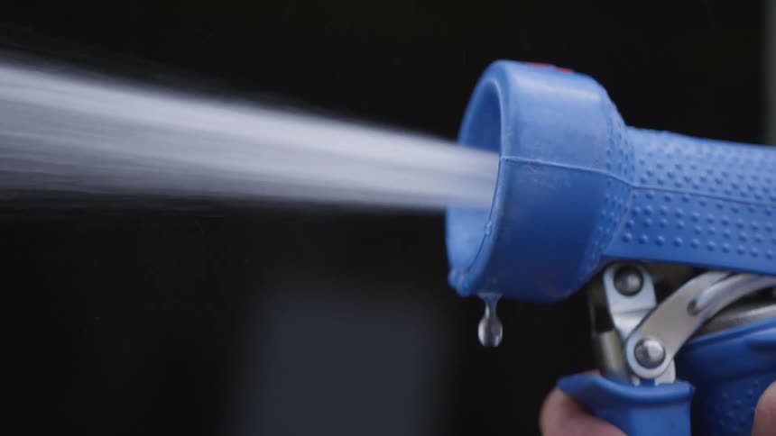 A blue hose tool spurting water from the tip
