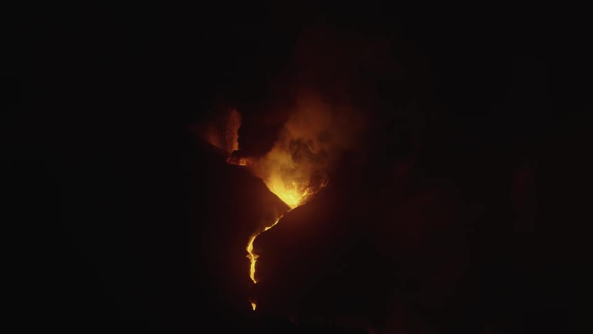 A volcano in the middle of a mountain is spewing lava and fire
