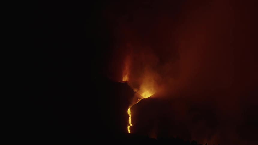 A volcanic eruption with bright lava and ash against a dark background