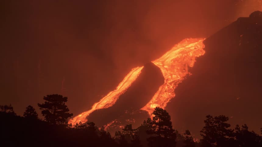Lava from a volcano flowing at night in time lapse
