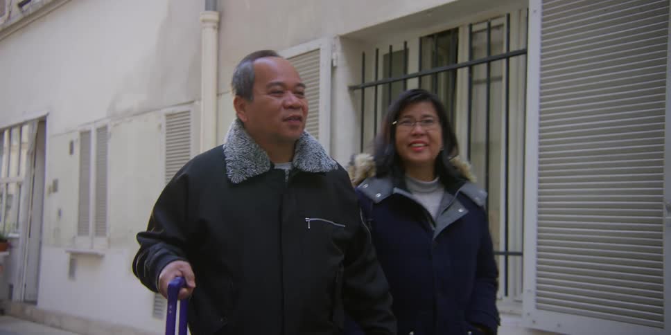 A couple in warm clothing having a conversation while walking on the street