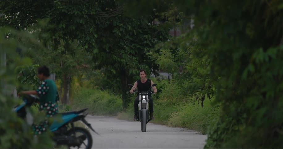 Woman on moped pulls onto intersecting road to allow male motorcyclist to pass