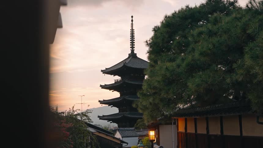 A tall traditional pagoda in a town at evening