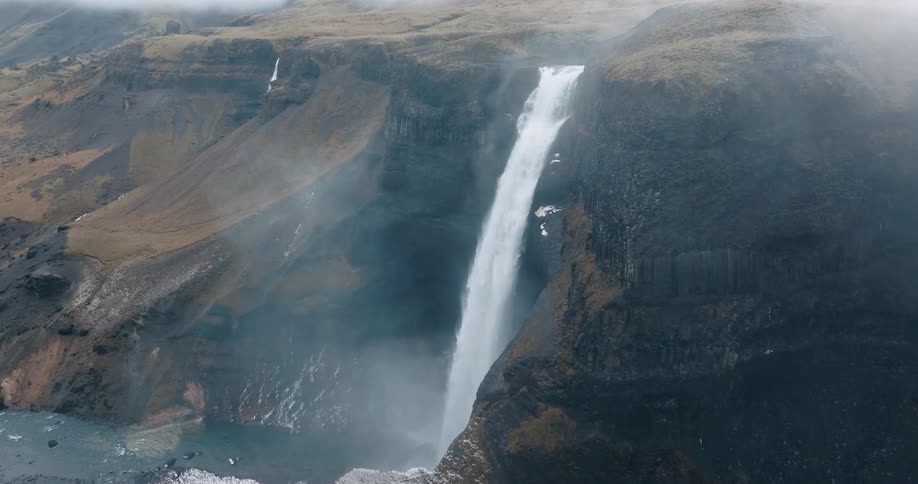 A huge waterfall drops water down a steep cliff