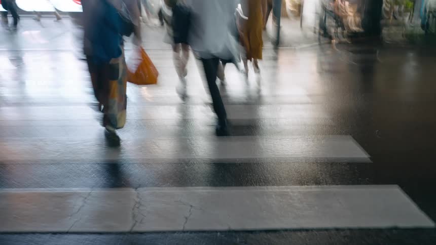 Crowd of people walking and crossing streets in a metropolitan city at night