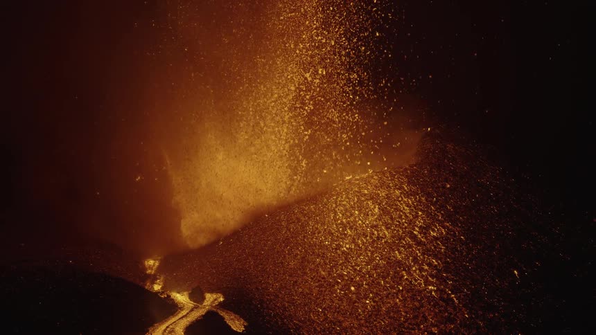 Lava gushes from a volcanic crater at night