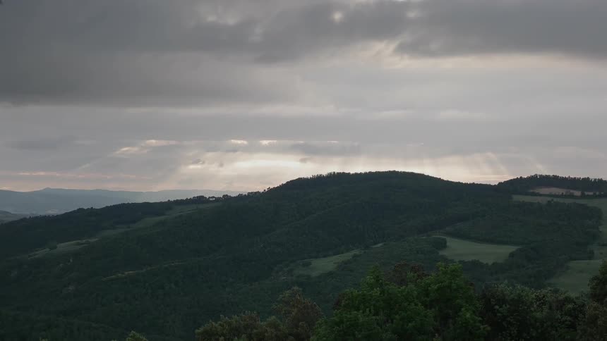 Sun rays shine down atop a mountain