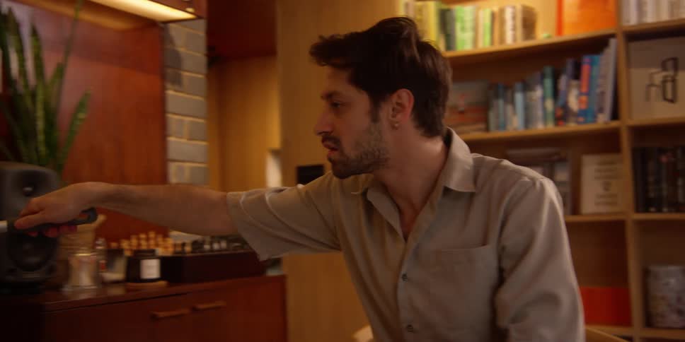 Young man dances while cleaning the apartment