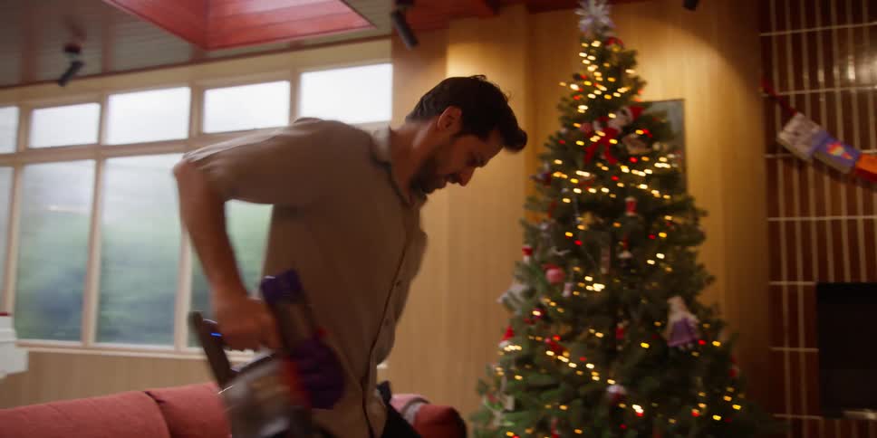 A man is vacuuming his home