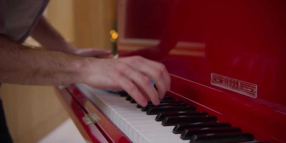 Man cleaning piano keyboard plays with piano keys