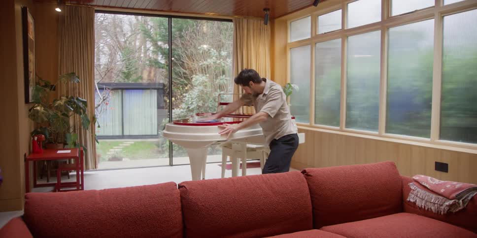 Man cleaning objects in a room while dancing