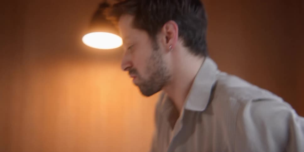 A man putting a pillow on the bed