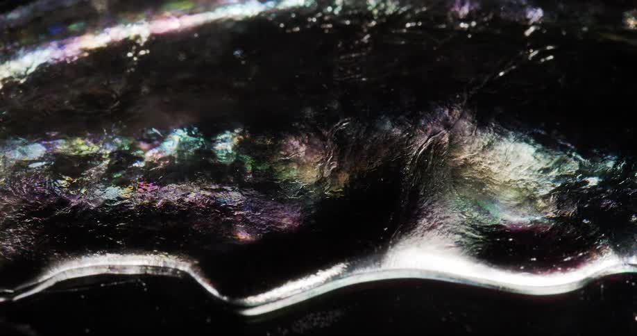 A viscous and translucent liquid slowly flows and ripples
