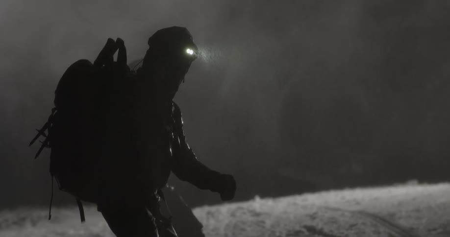 A clip of two hikes walking in the rain and snow at night