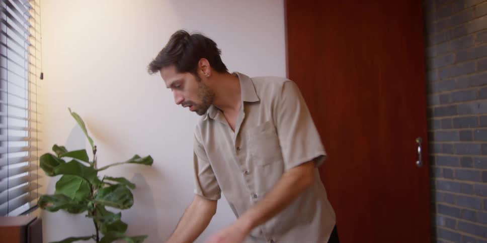 A man is dusting his home