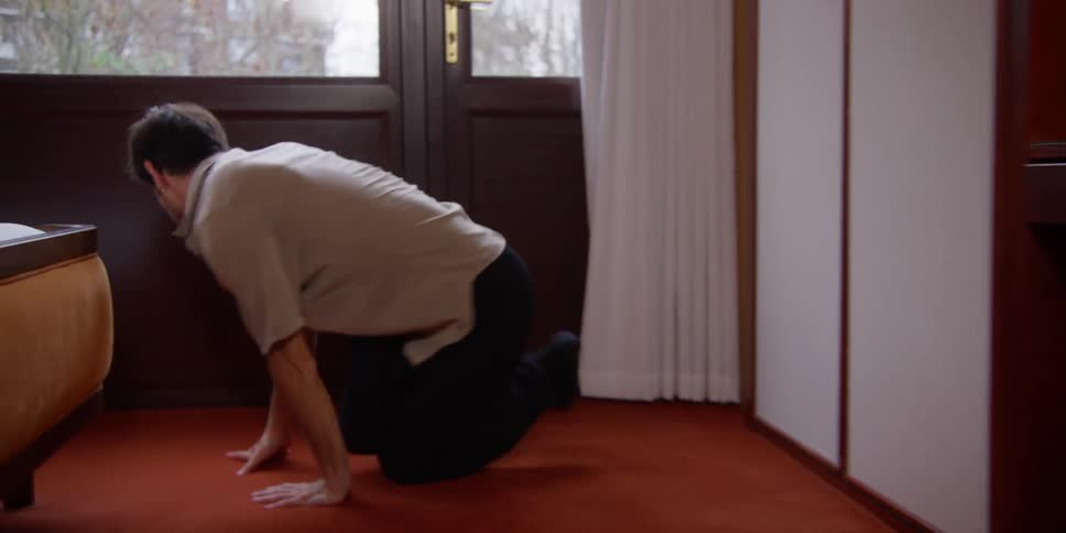A man dancing while cleaning the house