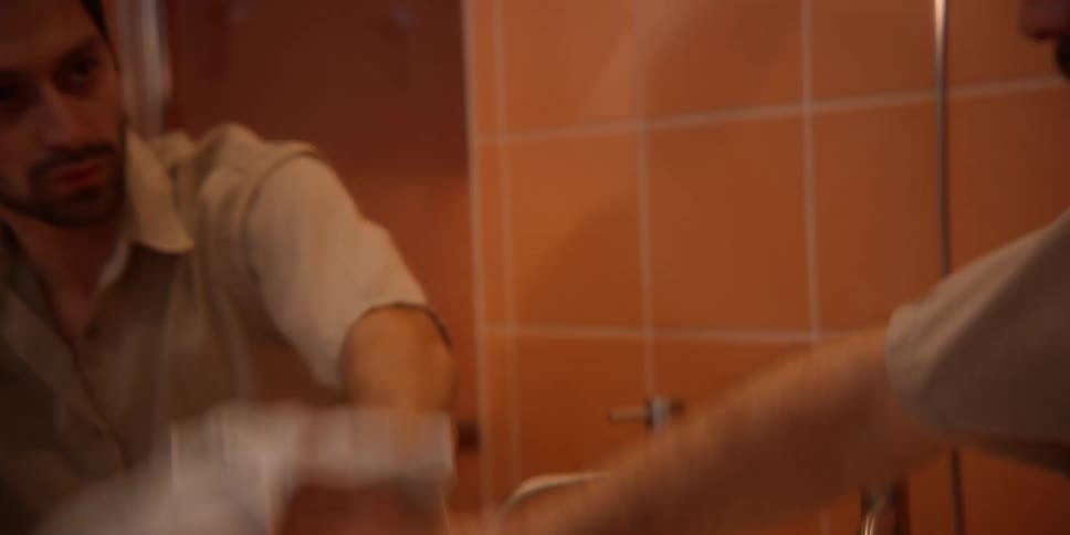 Man wiping the mirror in the bathroom