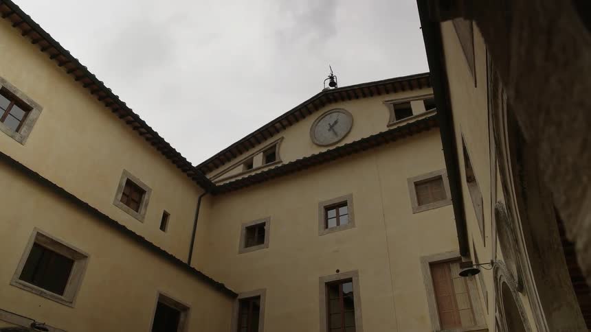 A clock ticks at the top of a building