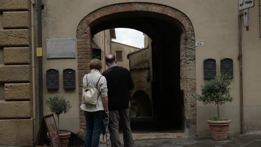 Two people standing in front of arch of city building
