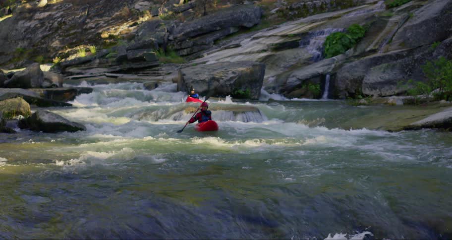 Two people kayaking down a river