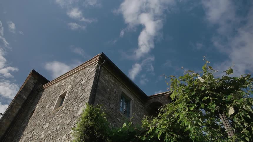 Light clouds hover over an old stone building