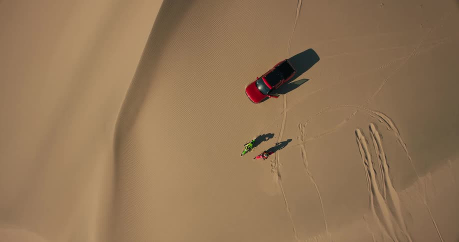 Aerial of people in the desert riding motorcycles during a hot day