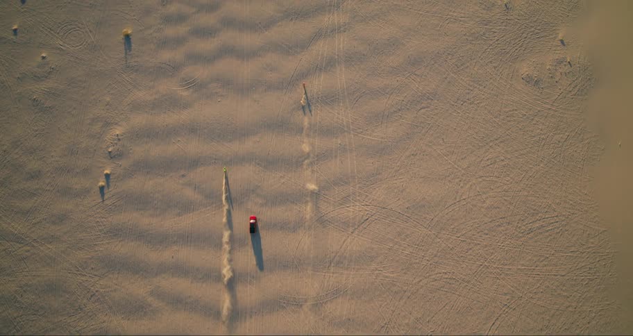 Aerial panorama of two motorcycles in one vehicle traveling in the same direction across the desert sands