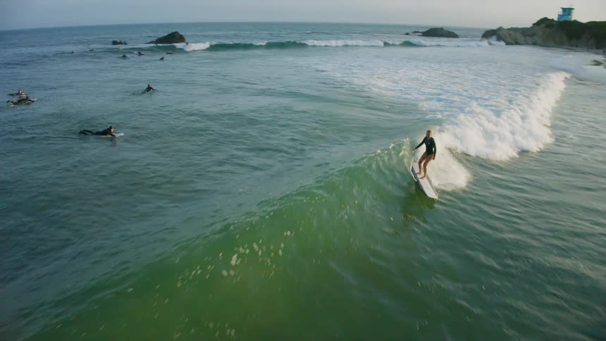Woman surfing a wave with a long board