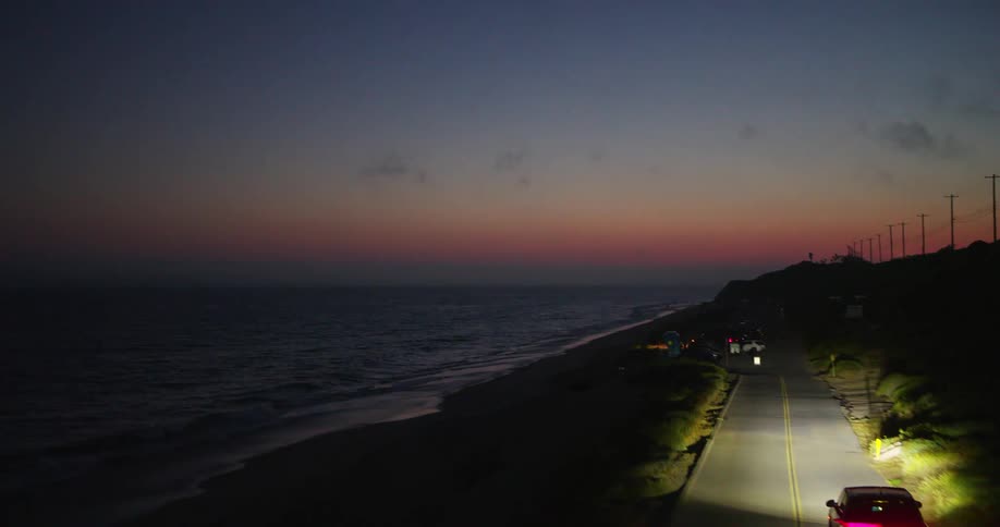 A clip of a moving truck in the night beside the sea shore