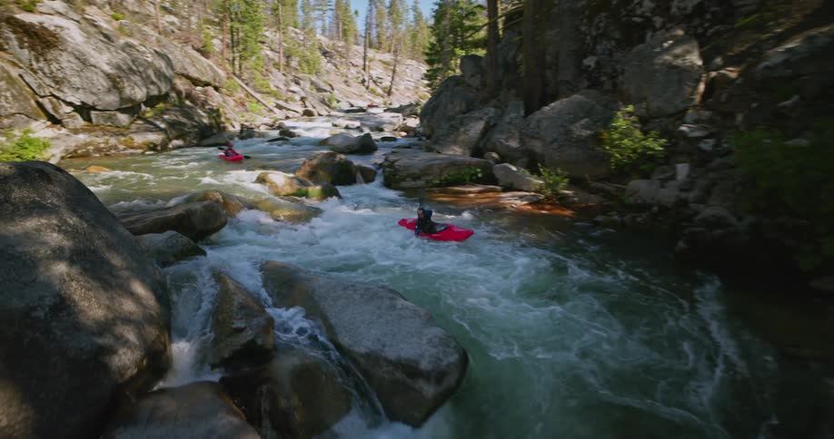Two people canoeing down a river
