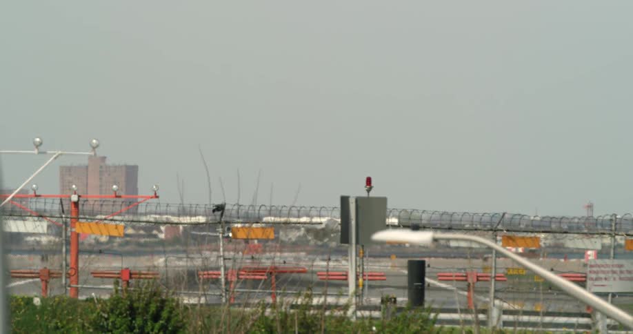 A plane is landing at an airport on a sunny day