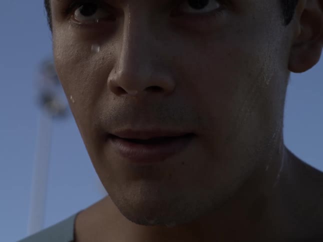 A young mans face is dripping with sweat