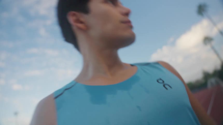 A young man on a race track stares into the distance