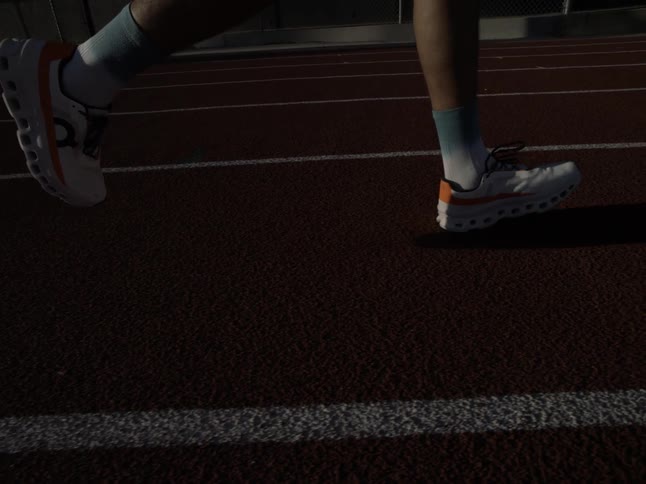 Closeup of a persons sneakers running on an athletics track