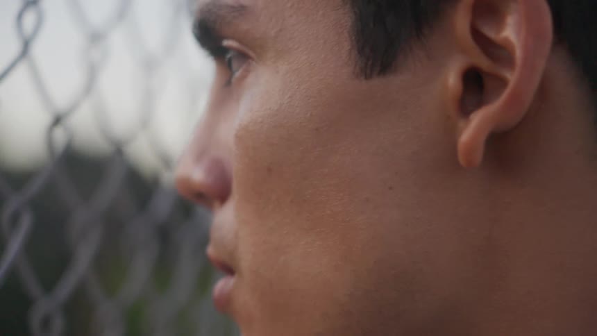 A man is standing by the fence