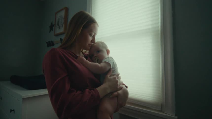 A mother cuddles with her infant son
