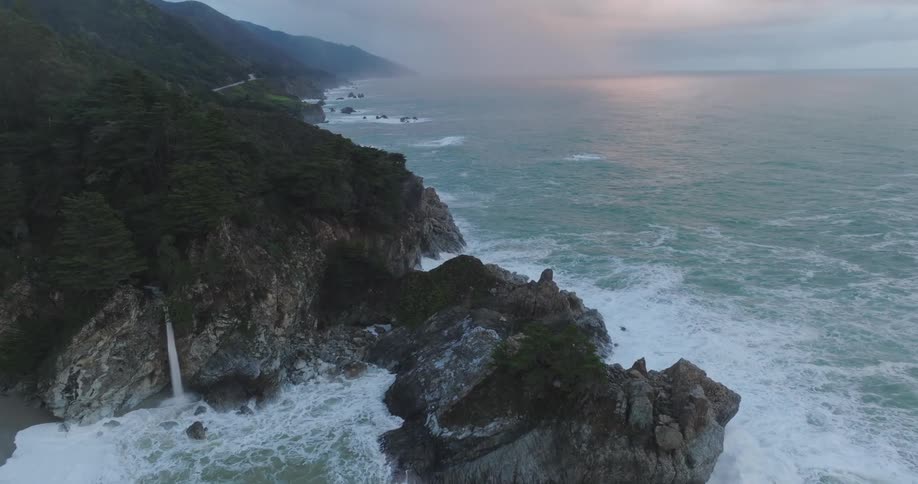 An aerial view of a rocky coastline with some waves crashing onto the shore